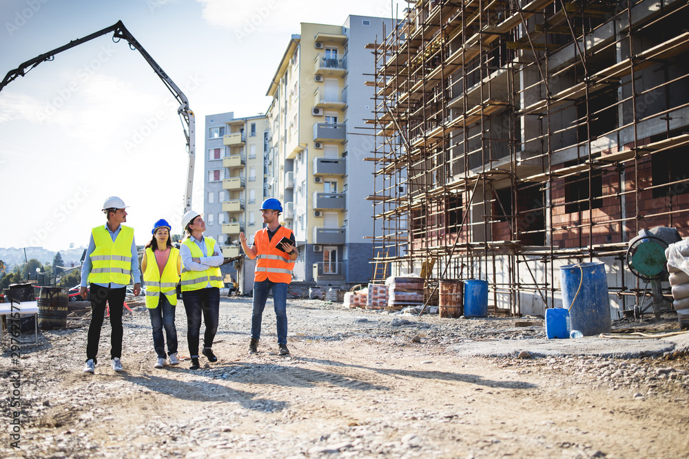 construction site with group of workers in bright vests